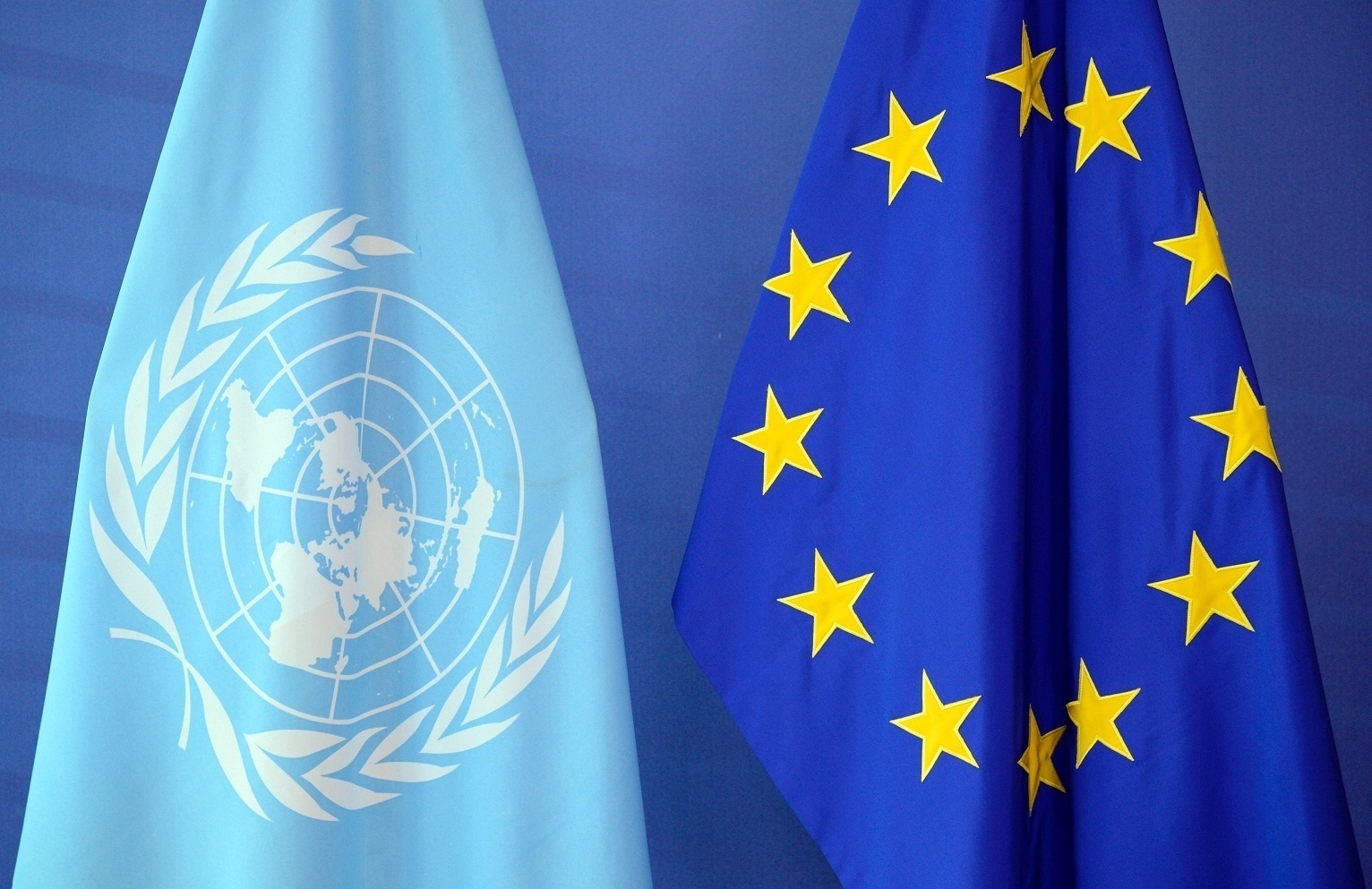 The United Nations flag (L) is seen next to the European Union flag at the European Union Commission headquarters in Brussels on June 14, 2016.